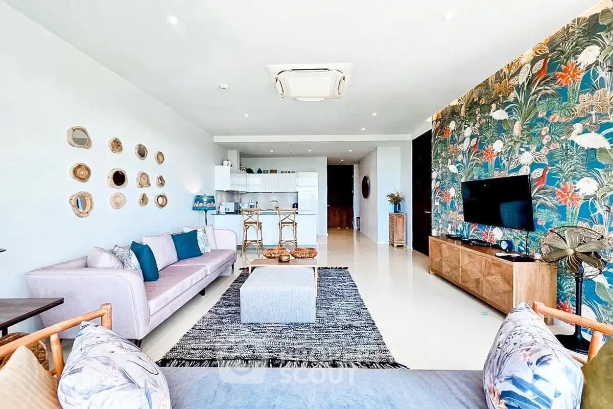 Spacious living room with modern decor and vibrant feature wall in luxury apartment.