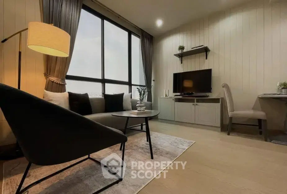 Modern living room with stylish furniture and large window offering natural light