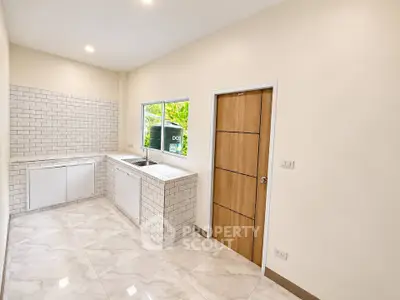 Modern kitchen with sleek white tiles and ample natural light
