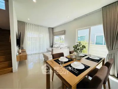 Modern open-plan living and dining area with natural light and stylish decor