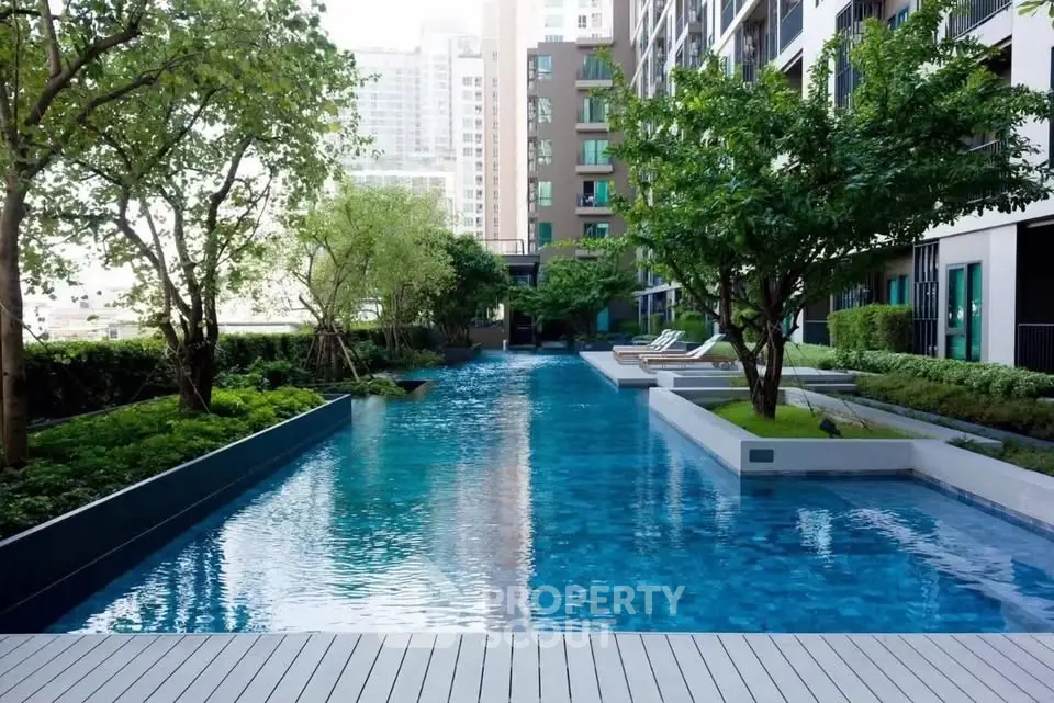 Luxurious residential pool area with lush greenery and modern design.