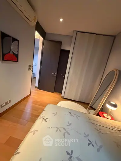 Cozy bedroom with modern decor, featuring a stylish mirror and soft lighting for a relaxing ambiance.
