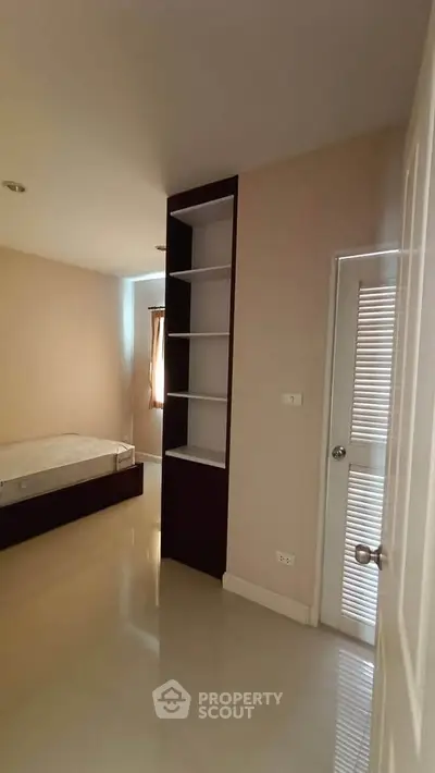 Spacious bedroom with built-in shelves and natural light