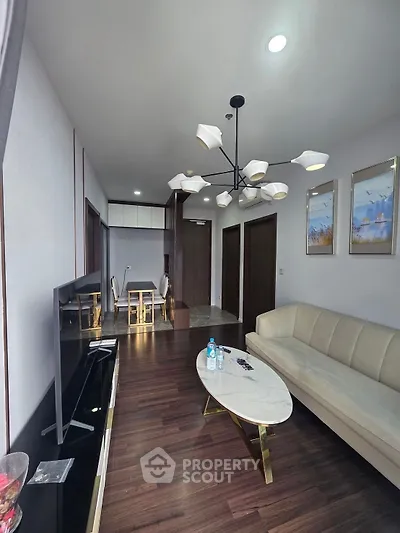 Elegant living room with modern chandelier and stylish furniture, perfect for contemporary living.