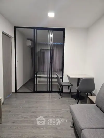 Modern apartment interior with sleek sliding glass doors and minimalist furniture design.