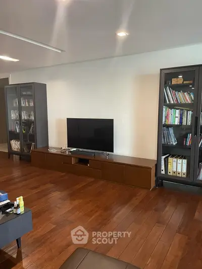 Spacious living room with wooden flooring and modern TV setup