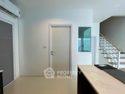 Modern minimalist living room with ample natural light, sleek staircase, and a clean, neutral color palette, perfect for personal customization.