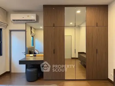 Modern bedroom with mirrored wardrobe and sleek desk area