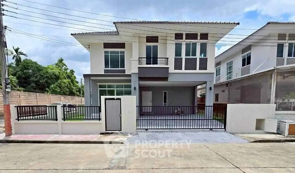 Modern two-story house with sleek design and spacious driveway in a suburban neighborhood.