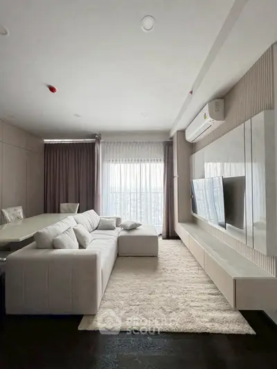 Modern living room with sleek design, featuring a plush sofa, wall-mounted TV, and large window with elegant curtains.