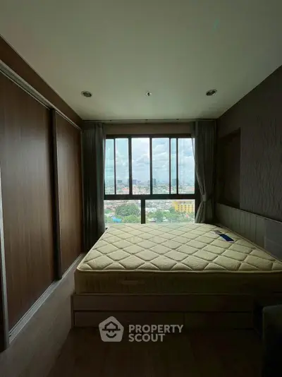 Cozy bedroom with large window offering stunning city views, featuring a comfortable bed and modern design.