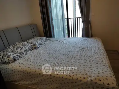 Cozy bedroom with large bed and balcony access in modern apartment