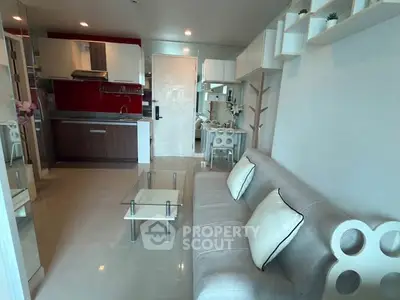 Modern living room with open kitchen, sleek furniture, and stylish decor in a contemporary apartment.