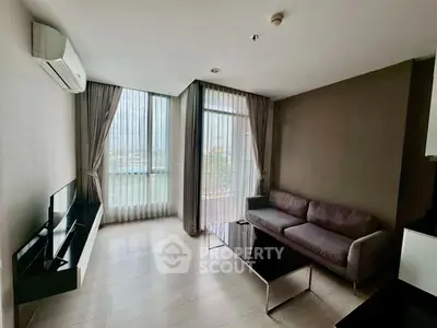 Modern living room with large windows and stylish furniture, offering a bright and inviting atmosphere.