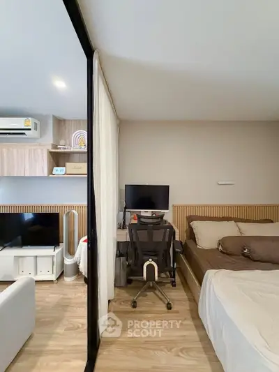 Modern studio apartment with cozy bedroom and workspace, featuring sleek furniture and stylish decor.