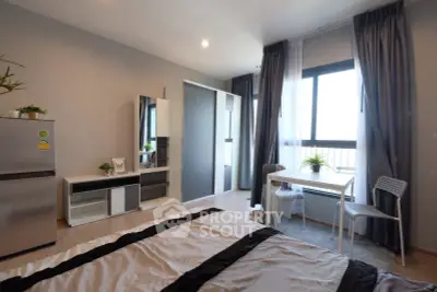 Modern bedroom with stylish decor, large window, and sleek furniture in a contemporary apartment.