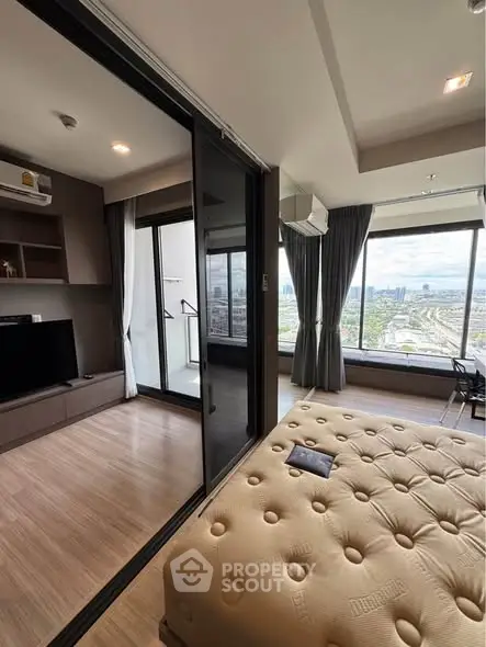 Modern bedroom with city view and balcony access in high-rise apartment
