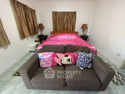 Cozy bedroom with stylish sofa and vibrant decor, perfect for relaxation and comfort.