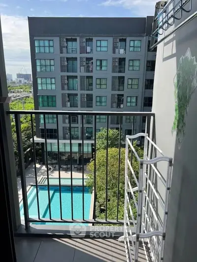 Modern apartment balcony with pool view in urban setting, perfect for city living.