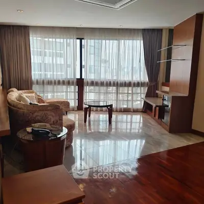 Spacious living room with elegant furniture and large windows offering city views.