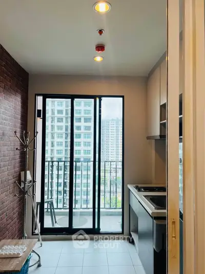 Modern kitchen with balcony view in high-rise apartment, featuring sleek cabinetry and ample natural light.