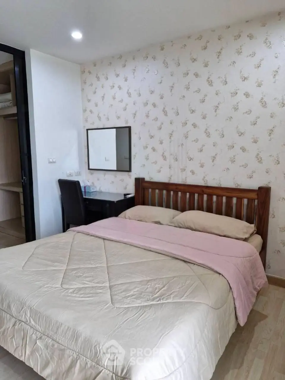 Cozy bedroom with floral wallpaper and wooden bed frame in modern apartment.
