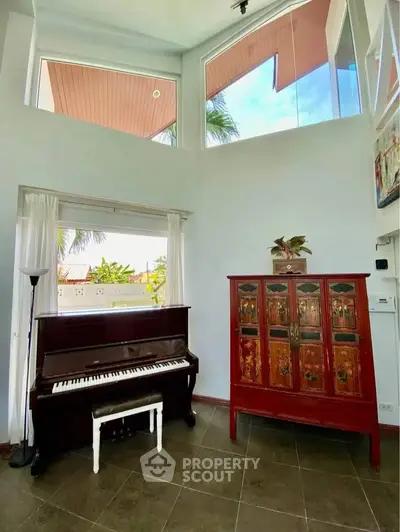 Spacious living room with high ceilings, large windows, and elegant piano, perfect for music lovers.