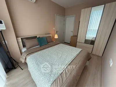 Cozy bedroom with modern decor and ample natural light, featuring a stylish wardrobe and comfortable bedding.