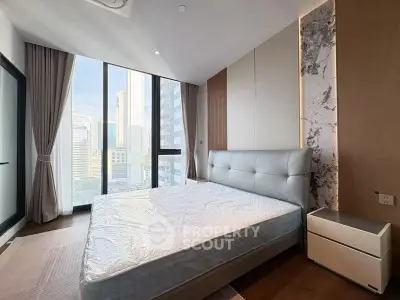 Luxurious bedroom with floor-to-ceiling windows offering stunning city views in a modern high-rise apartment.