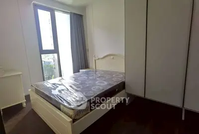 Bright bedroom with large window and modern furnishings in a stylish apartment.