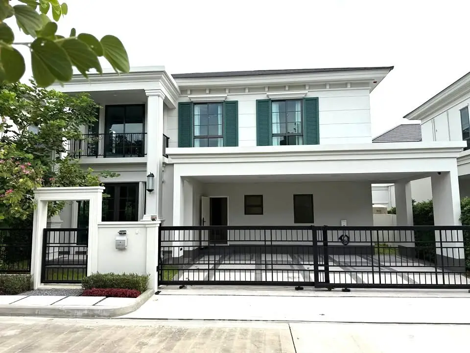 Elegant two-story house with green shutters and spacious driveway in a serene neighborhood.