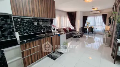 Modern open-plan kitchen and living room with stylish decor and ample natural light.