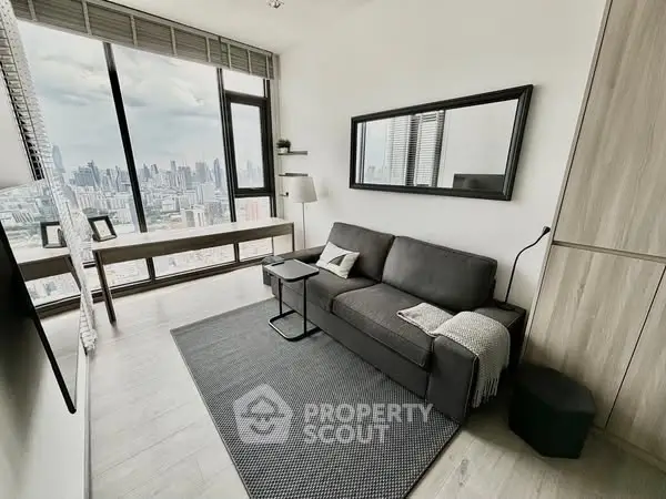 Modern living room with stunning city view, sleek furniture, and large windows in a high-rise apartment.