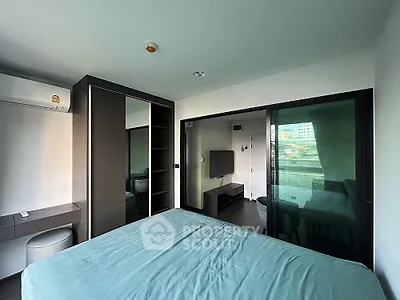 Modern bedroom with sleek design and large window offering natural light and city view.
