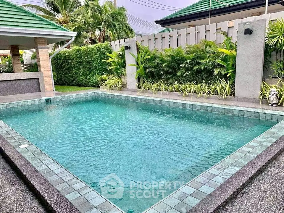 Luxurious private pool surrounded by lush greenery in a serene backyard setting.