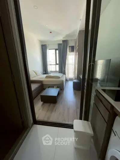 Modern studio apartment with cozy living area and large windows