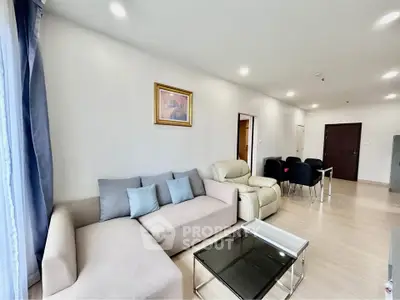 Spacious modern living room with elegant furniture and dining area in open layout.