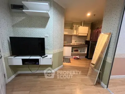 Cozy living room with TV and open kitchen layout in modern apartment.