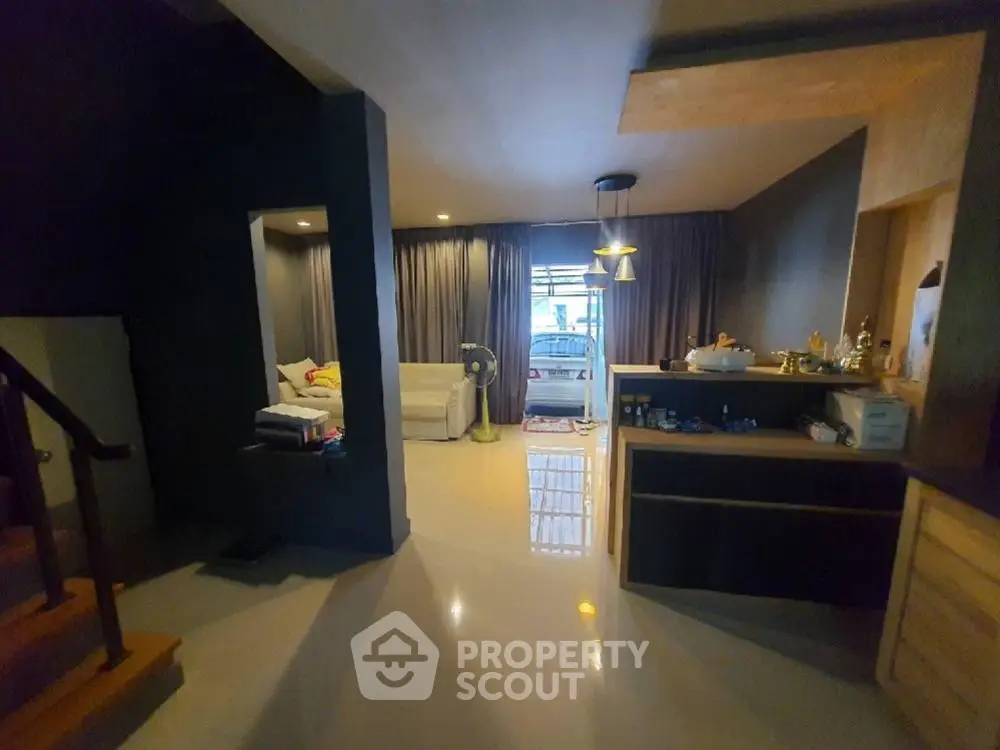 Spacious multi-level home interior with modern design, featuring an open-plan living area leading to a cozy balcony, elegant lighting, and sleek finishes.
