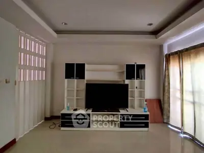 Spacious living room with modern entertainment center and natural light