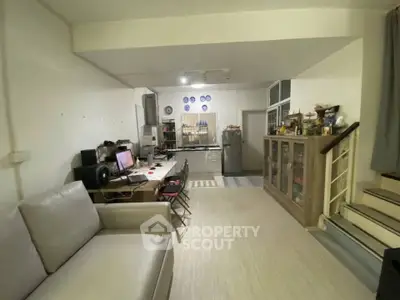 Spacious open-plan living room with modern kitchen and cozy seating area, perfect for entertaining.