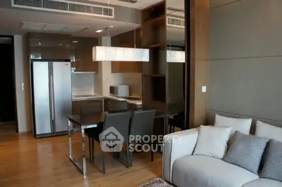 Modern open-layout kitchen and living room with sleek design and cozy ambiance.