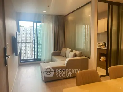 Modern living room with cozy sofa and city view from balcony.