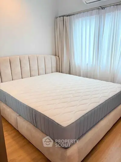 Cozy bedroom with plush bed and soft curtains, perfect for restful nights.