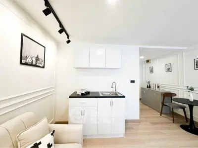 Modern minimalist living space with compact kitchenette and stylish decor.