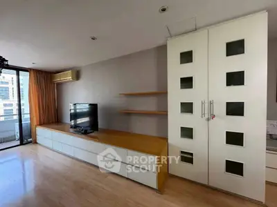 Spacious living room with modern entertainment unit and balcony view.