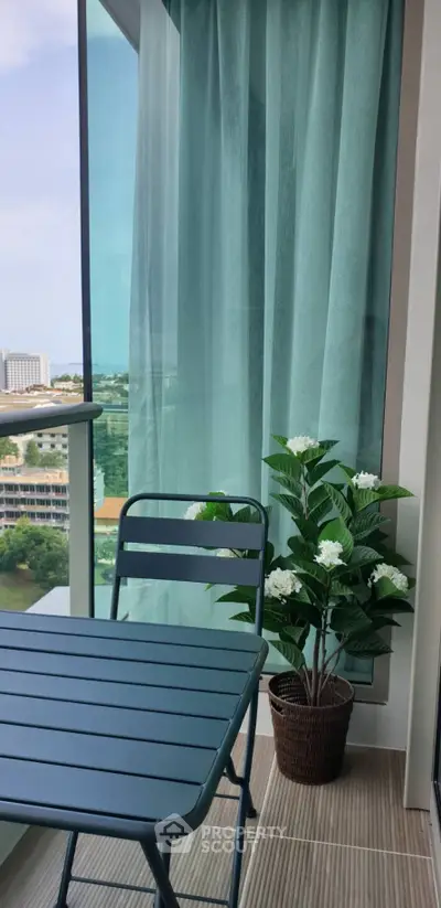 Charming balcony with modern furniture and lush view, perfect for relaxation.