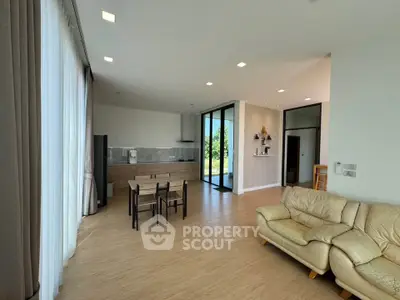 Spacious modern living room with open kitchen and natural light