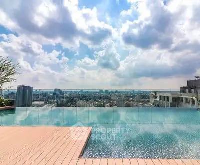 Stunning rooftop pool with panoramic city skyline view under a vibrant sky.
