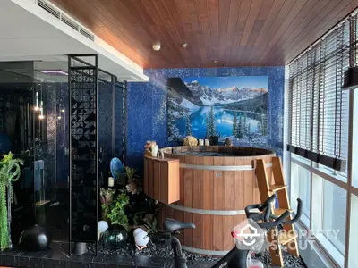 Luxurious home gym with scenic mountain mural and wooden hot tub